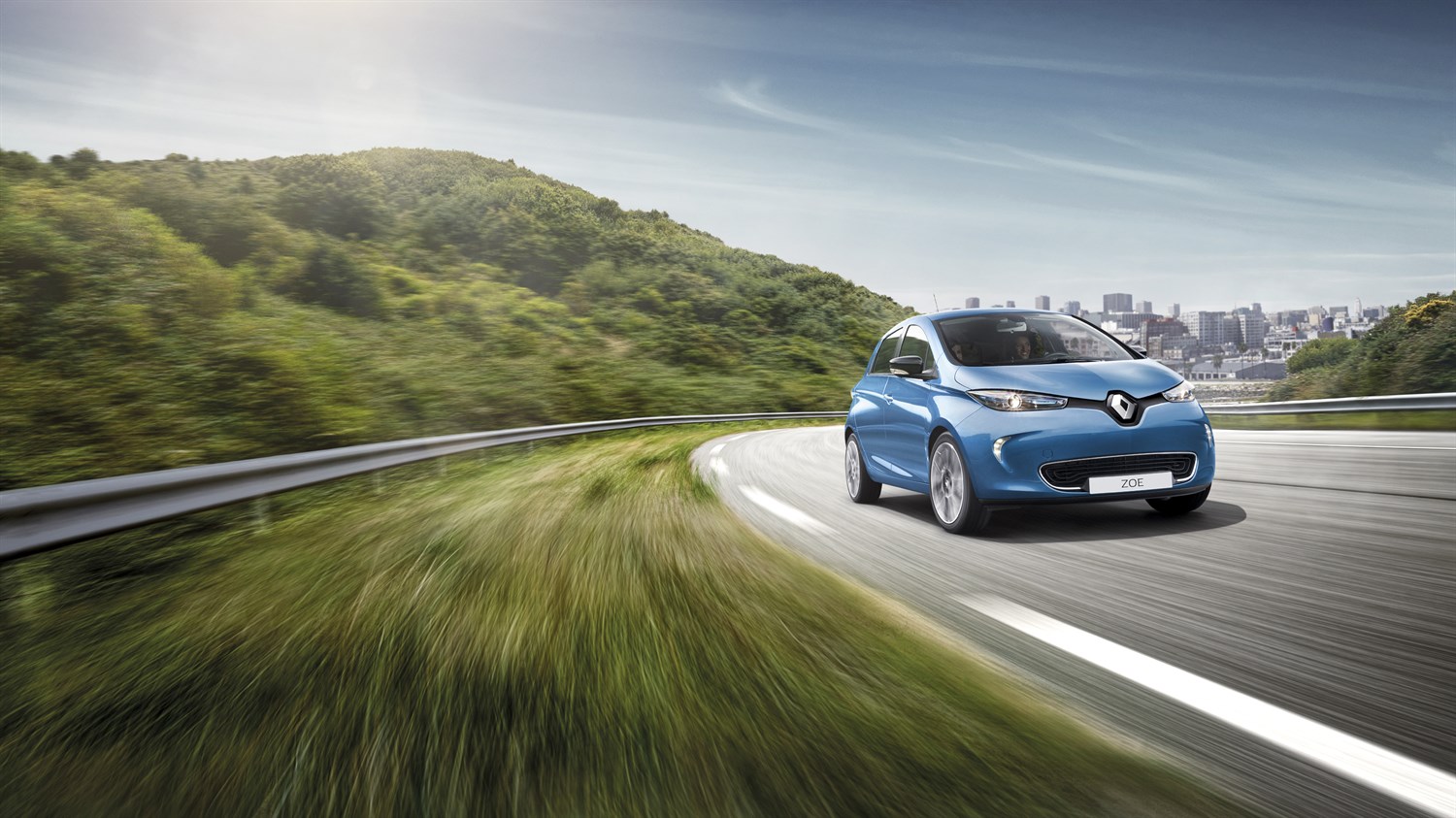 Renault ZOE - véhicule électrique dans un virage avec ville en arrière plan